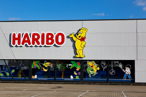 Mulheim-Karlich, Germany - February 27, 2021:: facade of the Haribo Outlet Store with the famous yellow Haribo bear. Haribo is a German confectionery company