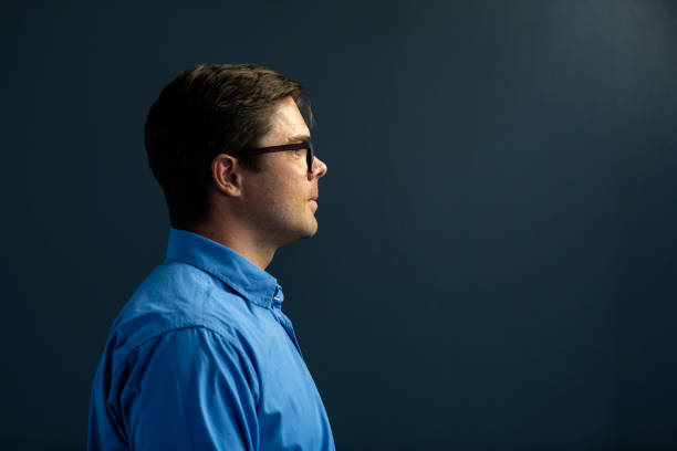 istock Side view young businessman wearing spectacles on dark grey background 1304552255