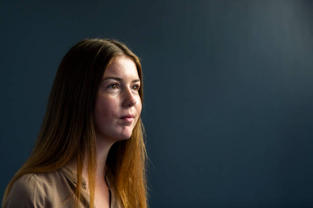 istock Portrait young woman on dark grey background 1304552279