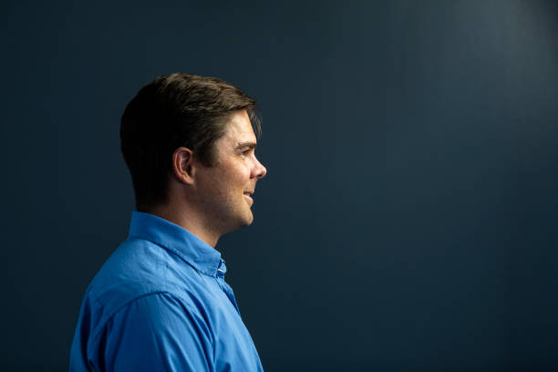istock Side view portrait smiling young businessman on dark grey background 1304552283