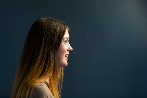 istock Portrait side view happy young woman on dark grey background 1304552325