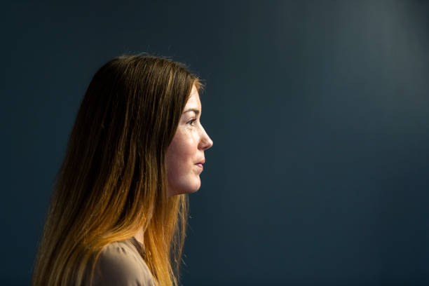 istock Portrait side view young woman on dark grey background 1304552372