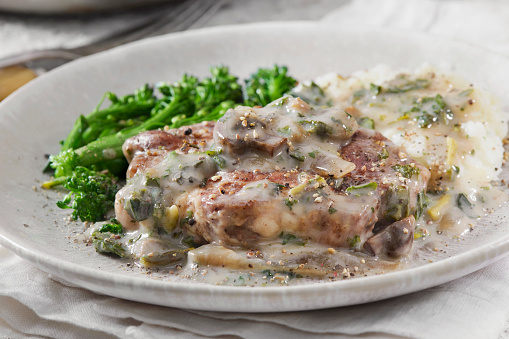 Pan Seared Pork Steak in a Creamy Mushroom Sauce with Onions and Fresh Spinach