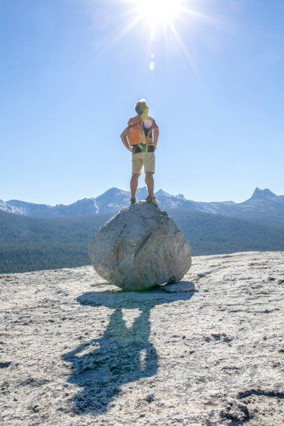 istock Hiker balances on a rock boulder above mountains 1304553457