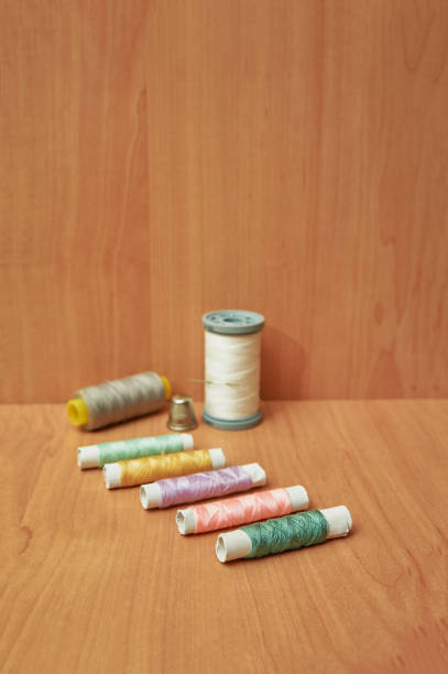 istock Close-up of colorful spool with thimble on wooden table. 1304553470