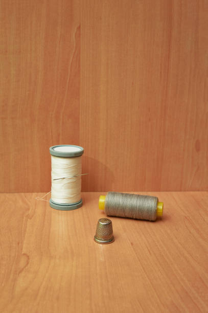 primer plano de carrete colorido con dedal sobre mesa de madera. - thimble sewing item close up studio shot fotografías e imágenes de stock