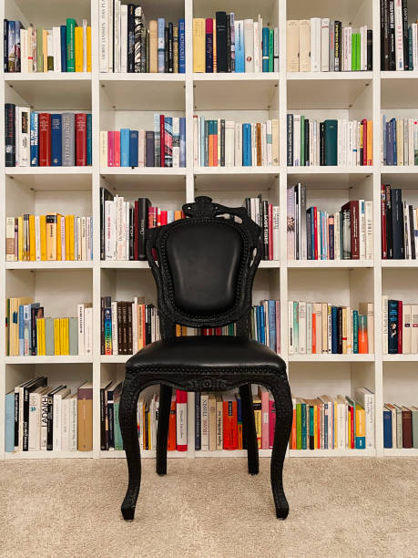 istock Library shelf with a black chair in front of it 1304553812