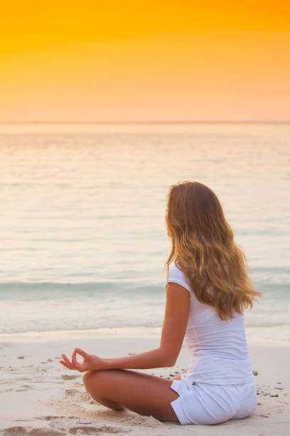 istock Yoga woman on beach at sunset 1304553818