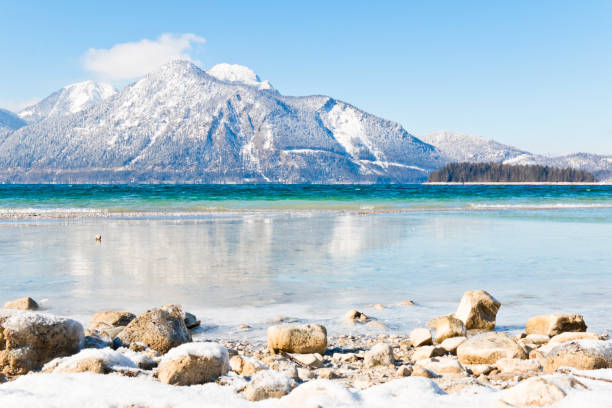 schneebedeckter berg an einem eisigen bergsee - walchensee lake stock-fotos und bilder