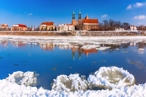 Panorama of Poznan Cathedral and ice drift on Warta River in the winter sunny day, Poznan, Poland