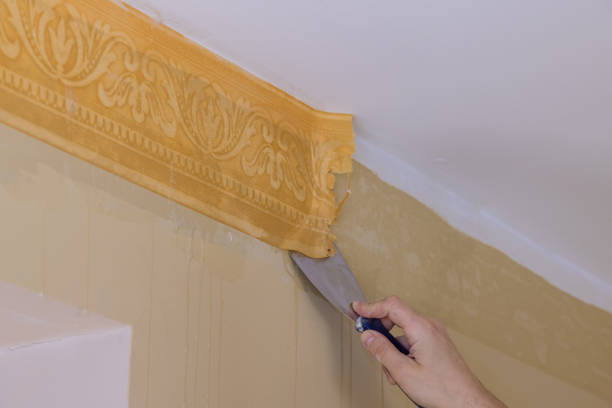 istock Making interior change preparing for home repair work man standing on metal ladder and tearing off old wallpaper from wall in room 1304555216