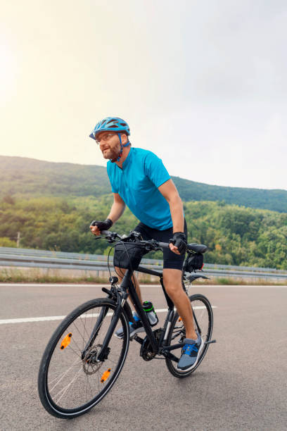 istock Young caucasian man riding a bicycle on the road 1304555293