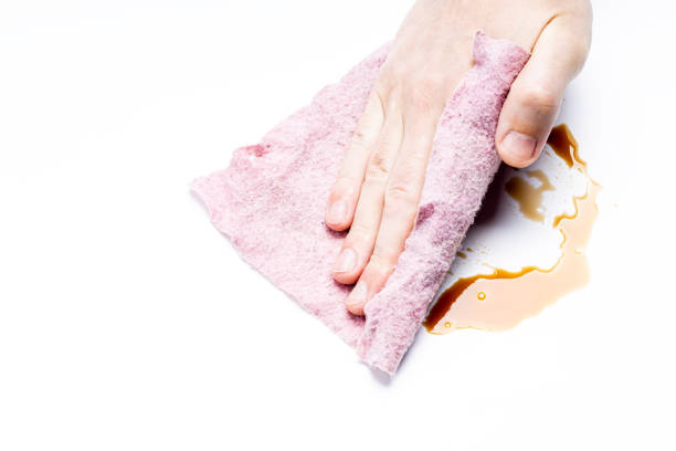istock cleaning or wiping symbol. person use rag to clean dark liquid from white surface 1304557515