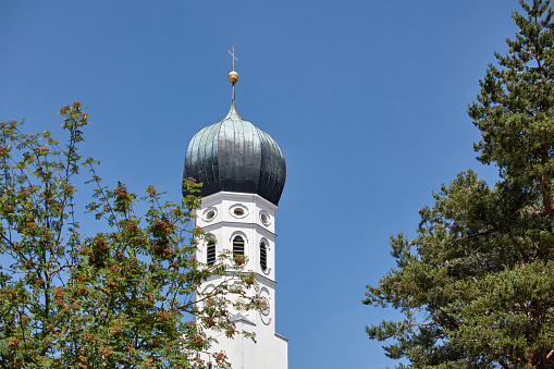 Tower of the 17th-century Dom St. Stephan (St. Stephen's Cathedral) in Passau, Germany, seen against a blue sky on a sunny day.