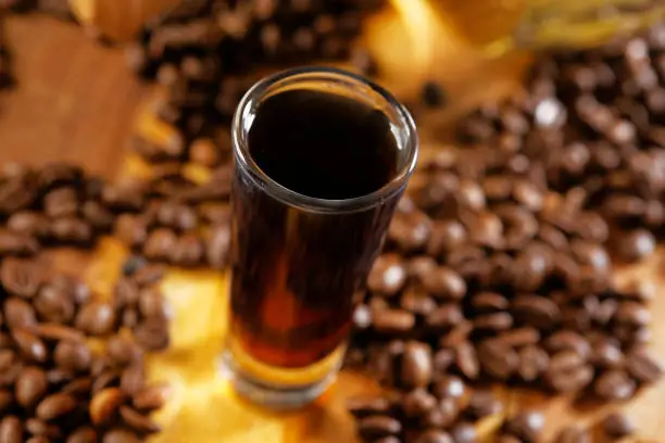 Photo of Tequila with coffee liqueur served in shot glass and accompanied with coffee beans.