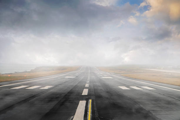 Empty runway strip with markings. Empty runway strip with markings at dusk, foggy day. airport runway photos stock pictures, royalty-free photos & images