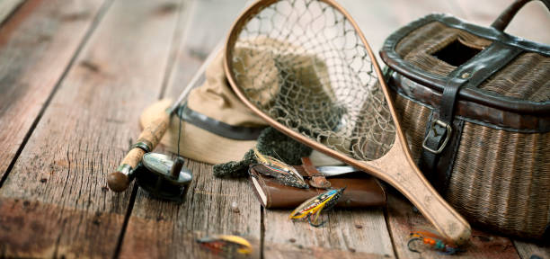 Vintage Wicker Creel and Fly Fishing Equipment Set against a Natural Wood Background