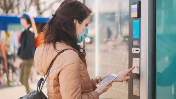 istock Woman paying contactless with smartphone at vending machine 1304563384