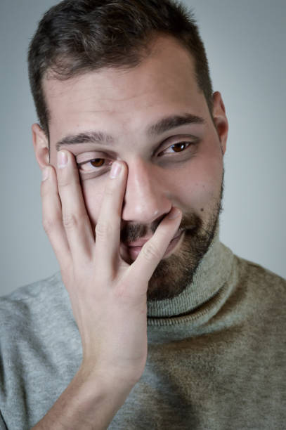 portret uśmiechniętego młodego mężczyzny zakrywa twarz ironicznym i pieszczoty - hiding turtleneck men humor zdjęcia i obrazy z banku zdjęć