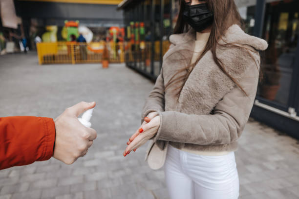 istock Young couple using hand sanitizer in the city 1304566878