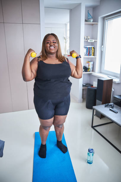 istock Inspired plus-size lady is exercising with dumbbells 1304566901