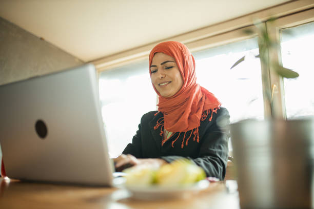 istock Beautiful businesswoman using laptop in cafeteria 1304568197