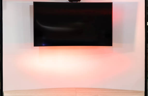 istock Large TV screen on a curved wall for your presentation with the multi-color backlight 1304570723