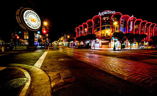 San Francisco, CA, USA - June 25th, 2015: Famous Fisherman's Wharf street and signage at night and Applebee's restaurant.