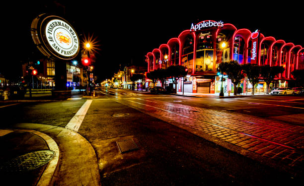 San Francisco San Francisco, CA, USA - June 25th, 2015: Famous Fisherman's Wharf street and signage at night and Applebee's restaurant. fishermans wharf stock pictures, royalty-free photos & images