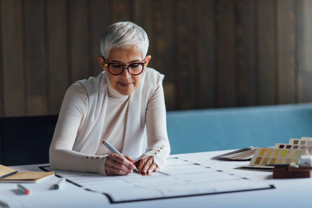 istock Elegant Senior Woman Architect Working on her Project in the Office 1304574796