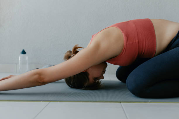 istock Child's Pose: Fit Woman Doing Yoga at Home 1304575015
