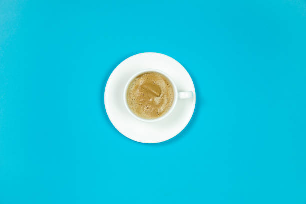 istock White cup of cappuccino with a saucer on a blue background. 1304578307