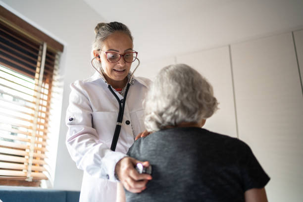 lekarz za pomocą stetoskopu do egzaminu starsza kobieta w domu - human heart human lung healthcare and medicine doctor zdjęcia i obrazy z banku zdjęć