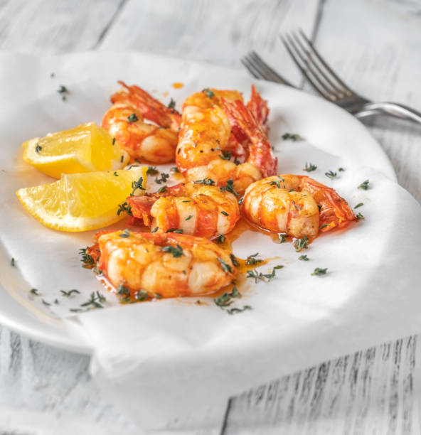 istock Shrimps with thyme and lemon wedges 1304583213