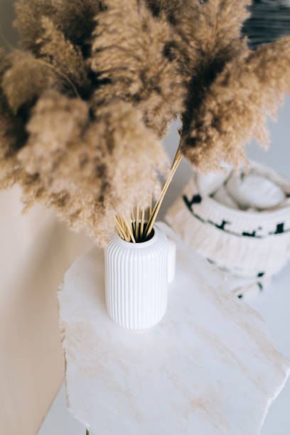 istock Dried flowers spikelets pampas in white vase on on a marble table. 1304583377