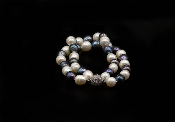 istock Beautiful pearl necklace on black background 1304584028