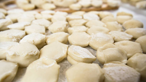 istock Handmade ravioli dumplings are beautifully arranged in rows on a cutting board and sprinkled with flour. Delicious homemade food and preparations. 1304584202