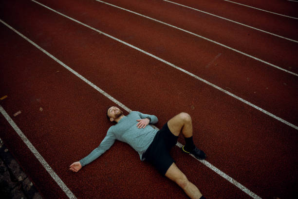 istock Caucasian male athlete lying down on tracking field 1304585685