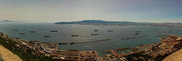 Aerial view of the Strait of Gibraltar taken on the rock of Gibraltar. Image shows hazy horizon with silhouettes of the Rif mountains of North Africa as well as a number of ships crossing the passage