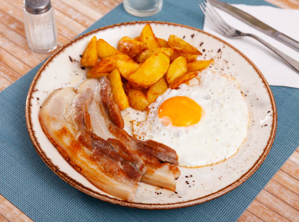 istock Plate of fried meat and potatoes served with fried egg 1304587156