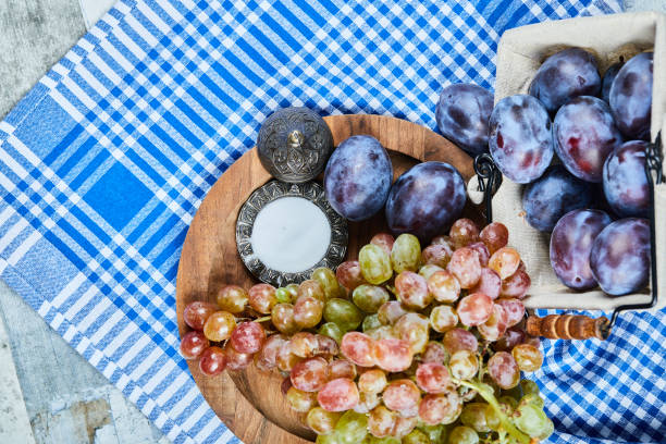 Fresh plums and a bunch of grapes on a tablecloth. High quality photo