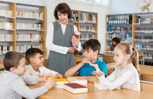 istock Female teacher and pupils working in classroom 1304588795