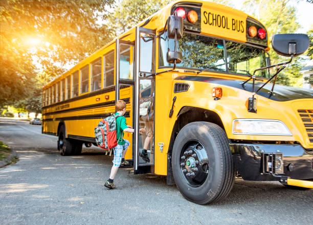 School bus A group of young children getting on the school bus backpack photos stock pictures, royalty-free photos & images