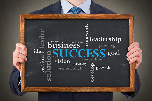 Success Concepts on Blackboard Background. Express using gears. The road to success. Goal, vision, ida, teamwork concepts brings success. Business man is drawing on chalkboard.