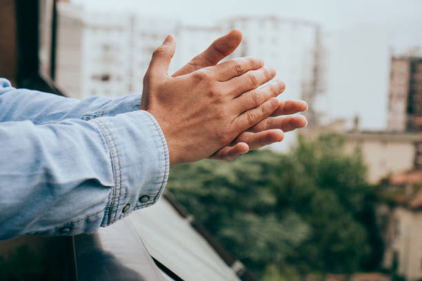 istock Man clapping on the balcony to support the mediacal staff during the coronavirus-alarmed state, covid-19. Sars. Applause. 1304591282