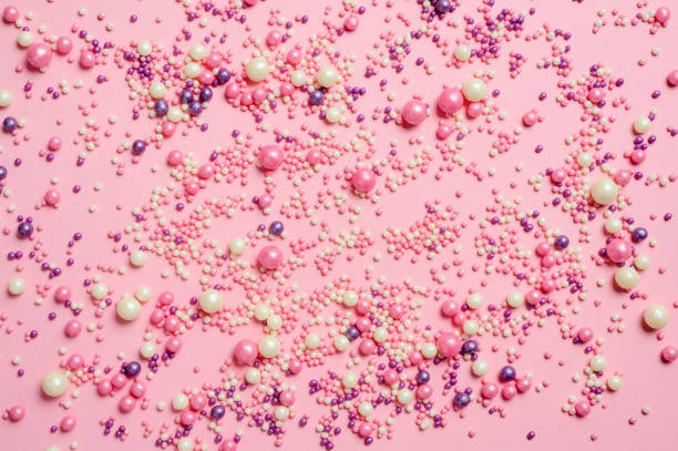 istock Many small multi-colored sweet balls on a pink background. 1304592144