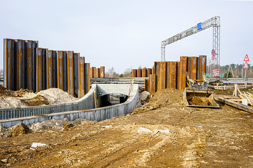 construction of a pedestrian tunnel under the highway, temporary metal retaining wall support the foundation