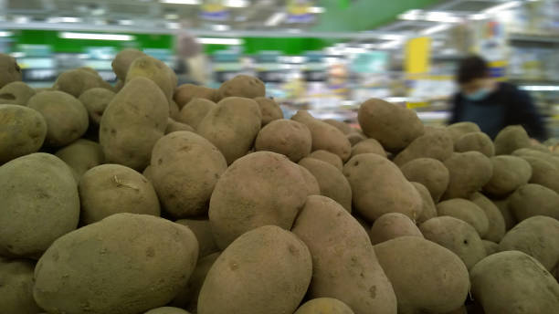 pile of potatoes on supermarket shelves for sale. vegetable background. healthy eating. concept of rising food price. farmers market. retail industry. grocery store. stall. natural products. - for sale industry farmers market market stall imagens e fotografias de stock