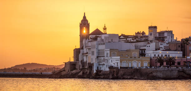 sunset in sitges with the sun behind the church steeple