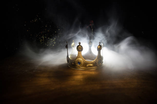 low key image of beautiful queen/king crown over wooden table. vintage filtered. fantasy medieval period low key image of beautiful queen/king crown over wooden table. vintage filtered. fantasy medieval period. Selective focus. Colorful backlight throne stock pictures, royalty-free photos & images